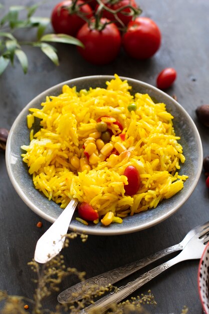 Comida india con arroz, maíz y tomates