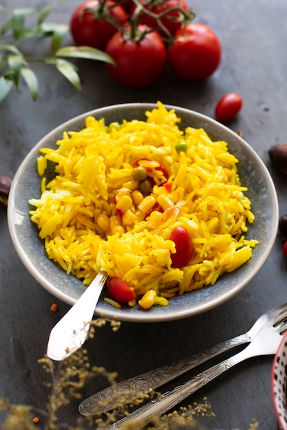 Comida india con arroz, maíz y tomates