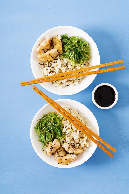 Comida japonesa. Tazón de arroz, pescado blanco hervido y ensalada de wakame chuka o algas. Vista superior. Lay Flat