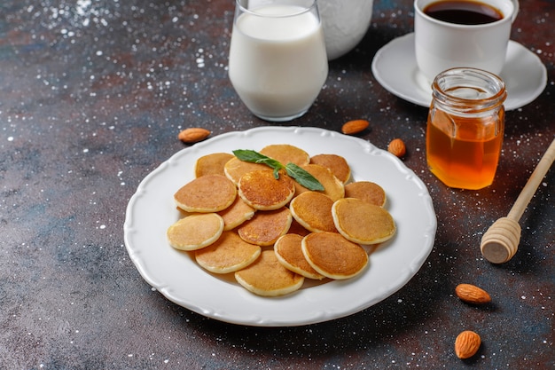 Comida de moda: mini cereal para panqueques. Montón de panqueques de cereales con bayas y nueces.