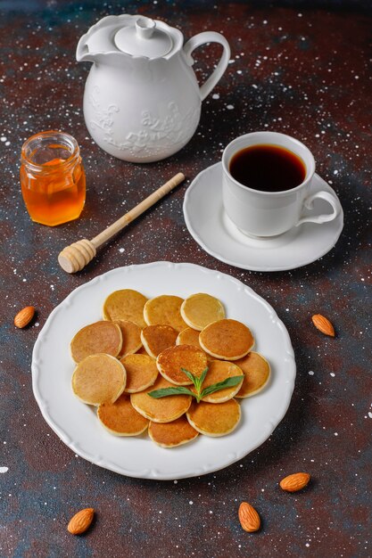 Comida de moda: mini cereal para panqueques. Montón de panqueques de cereales con bayas y nueces.