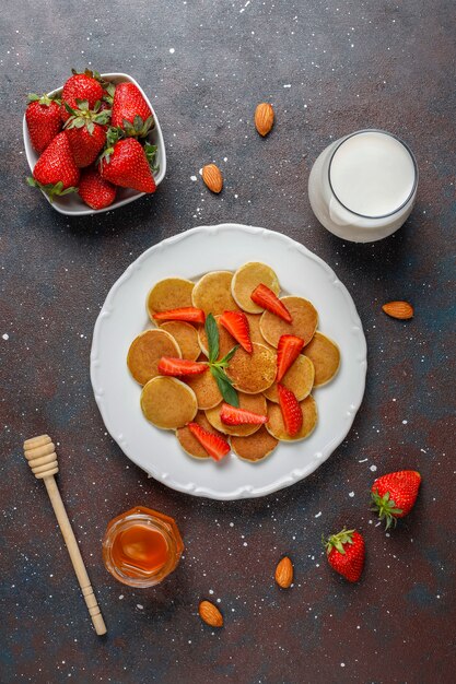 Comida de moda: mini cereal para panqueques. Montón de panqueques de cereales con bayas