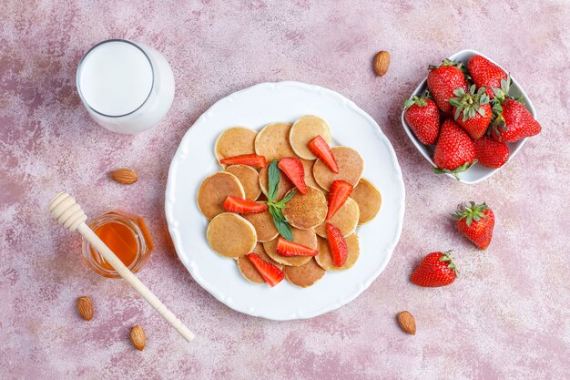 Comida de moda: mini cereal para panqueques. Montón de panqueques de cereales con bayas