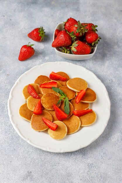 Comida de moda: mini cereal para panqueques. Montón de panqueques de cereales con bayas