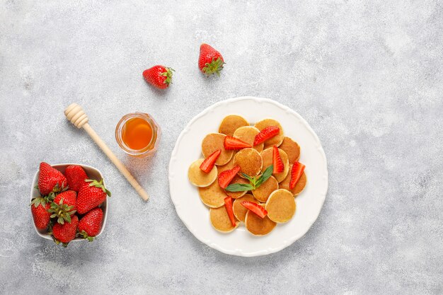 Comida de moda: mini cereal para panqueques. Montón de panqueques de cereales con bayas