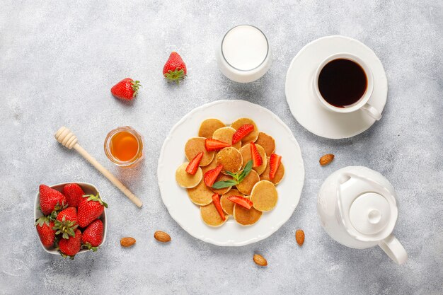 Comida de moda: mini cereal para panqueques. Montón de panqueques de cereales con bayas