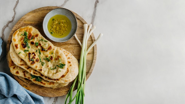 Comida pakistaní en tablero de madera con espacio de copia