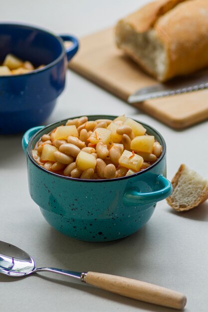 Comida plana con frijoles y patatas en una olla pequeña