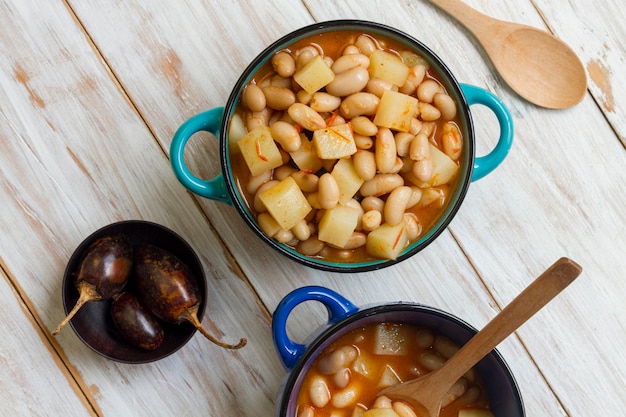 Foto gratuita comida plana con frijoles y patatas en una olla