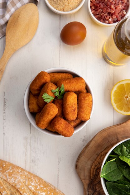 Comida que contiene croquetas con tocino y espinacas