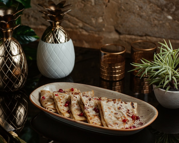 Comida rápida caucásica qutab, kutab, frito y servido con semillas de granada