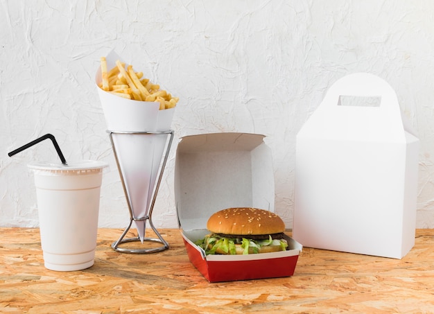 Comida rápida con vaso de eliminación y paquete de comida maqueta en el escritorio de madera