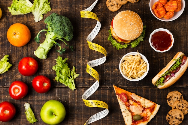 Comida rápida y verduras en la mesa de madera