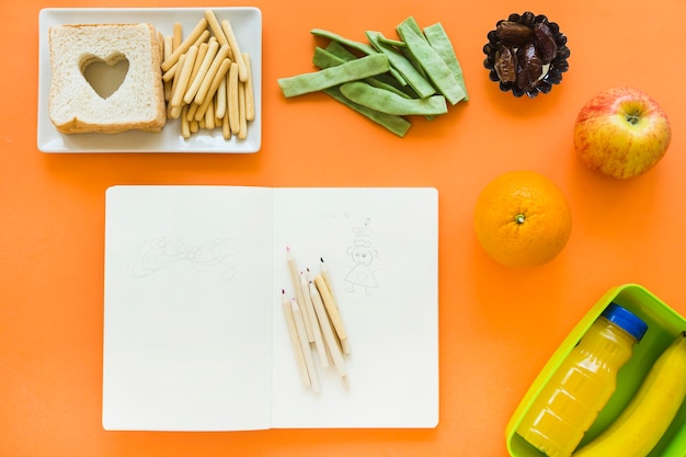 Foto gratuita comida sana alrededor del cuaderno abierto