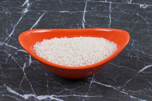Foto gratuita comida sana. arroz crudo en tazón de fuente naranja.