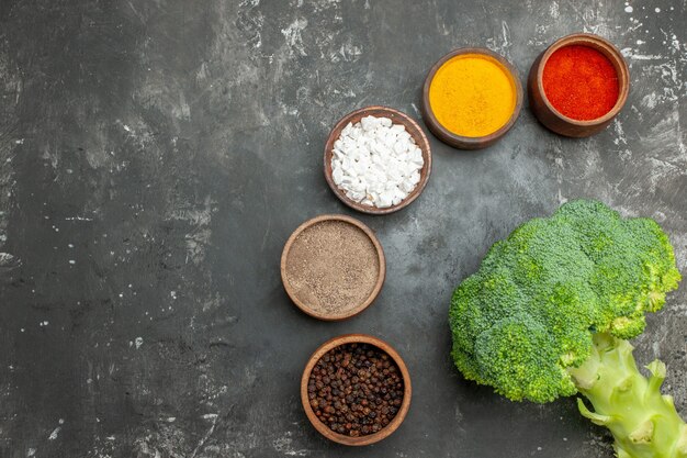 Comida sana con brocoli y zanahorias en un plato negro y especias