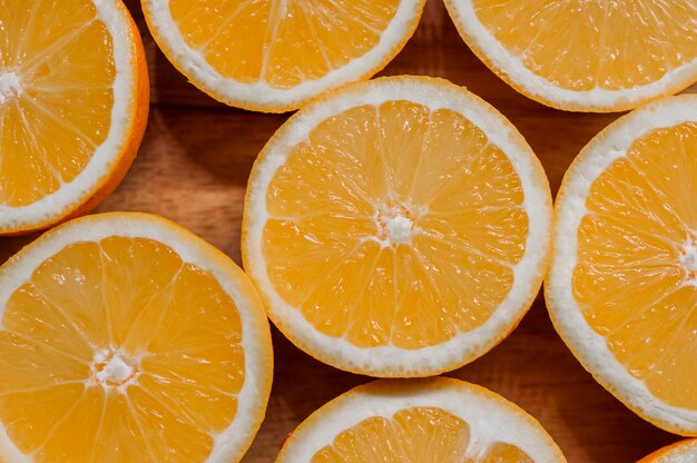 Comida sana, de fondo. Rebanadas de naranja como textura de fondo. Rodajas de naranjas frescas dispuestos en forma sobre fondo de madera