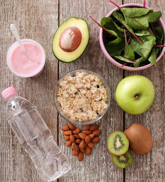 Comida sana, fruta, yogur, cereal y botella de agua.