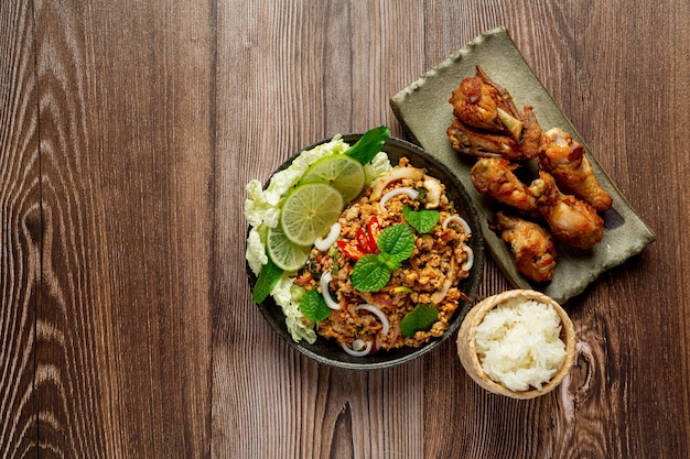 Foto gratuita comida tailandesa con carne de cerdo picada picante servida con arroz glutinoso y pollo frito