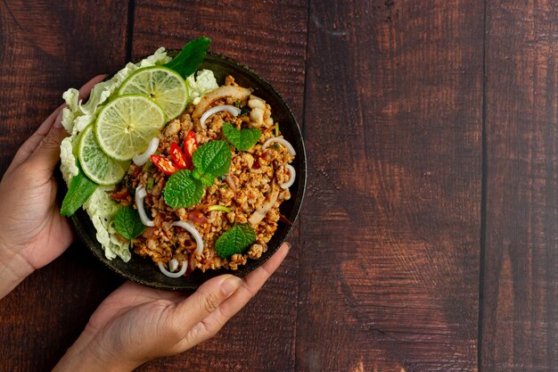 Comida tailandesa con carne de cerdo picada picante servida con guarniciones