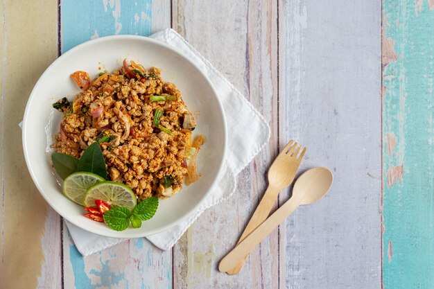 Comida tailandesa con carne de cerdo picada picante servida con guarniciones