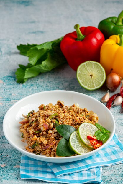 Comida tailandesa con carne de cerdo picada picante servida con guarniciones