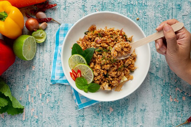 Comida tailandesa con carne de cerdo picada picante servida con guarniciones