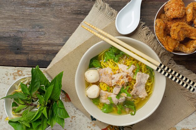 Comida tailandesa. Fideos con cerdo, albóndigas y verdura