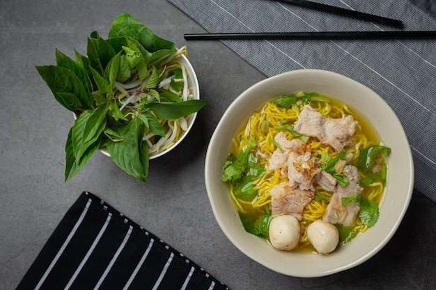 Comida tailandesa. Fideos con cerdo, albóndigas y verdura