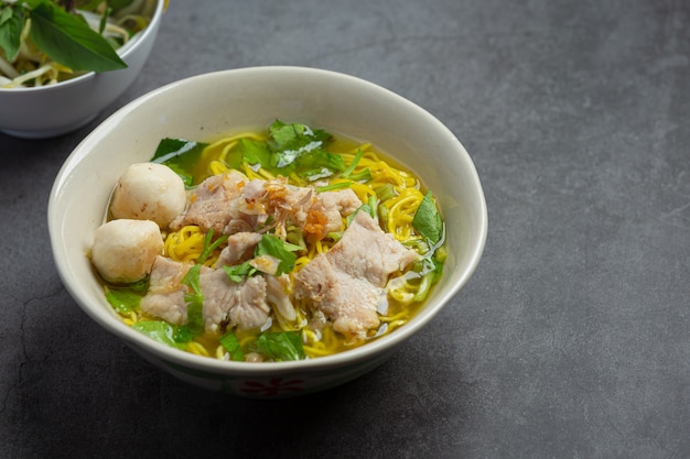 Comida tailandesa. Fideos con cerdo, albóndigas y verdura