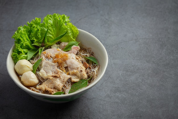 Comida tailandesa. Fideos con cerdo, albóndigas y verdura