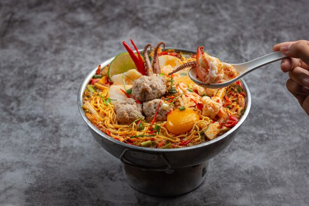 Comida tailandesa. fideos picante hervir con mariscos y cerdo en olla caliente