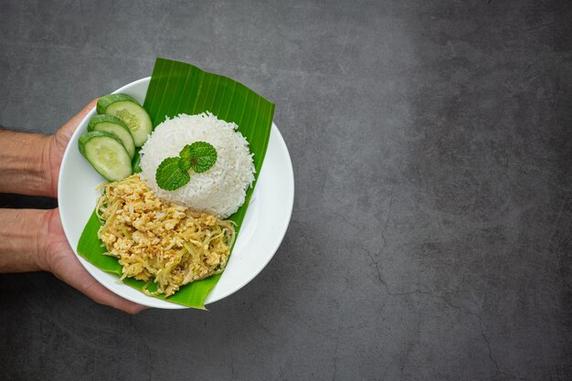 Comida tailandesa revuelva huevo frito con papaya cocida servir con arroz