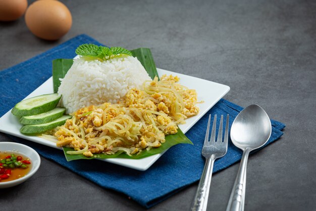 Comida tailandesa revuelva huevo frito con papaya cocida servir con arroz