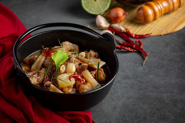 Comida tailandesa con sopa picante de pierna de cerdo en tazón negro