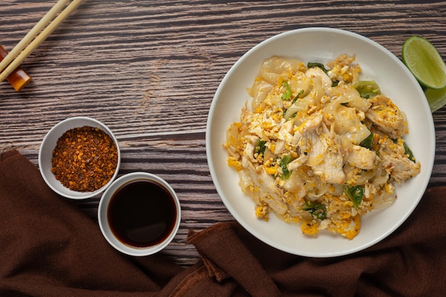 Comida tailandesa. Tallarines fritos con cerdo en salsa de soja y verdura