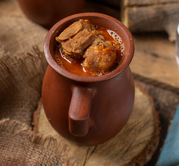 Comida tradicional azerbaiyana piti en taza de cerámica con carne.