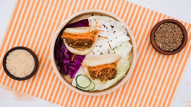 Comida tradicional gua bao en vapor con ensalada en mantel