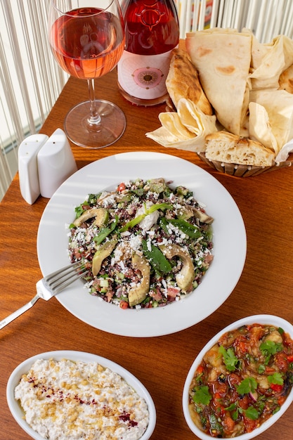 Una comida de verduras de vista superior con pan de carne y vino en la mesa durante la cena de comida diurna