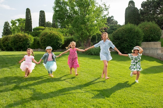 Comienzos divertidos. Concepto de moda infantil. El grupo de chicos y chicas adolescentes corriendo en el parque. Ropa colorida para niños, estilo de vida, conceptos de colores de moda.