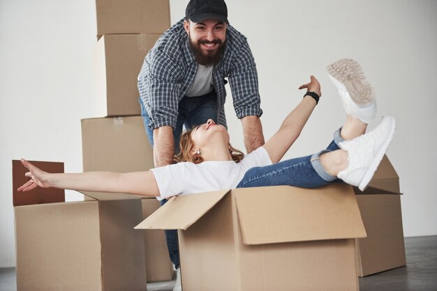 Como niños otra vez. Pareja feliz juntos en su nueva casa. Concepción de mudanza