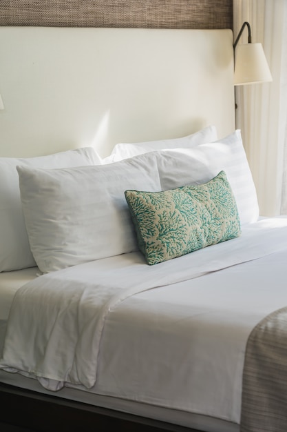 Cómoda almohada blanca en el interior de la decoración de la cama