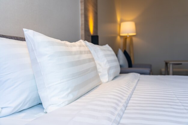 Cómoda almohada blanca en el interior de la decoración de la cama