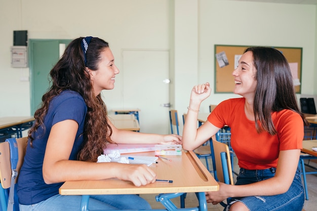 Compañeras de clase charlando y riéndose