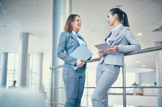 Compañeras de trabajo charlando antes de la reunión