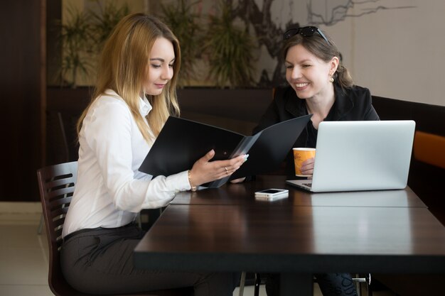 Compañeras de trabajo leyendo el informe financiero