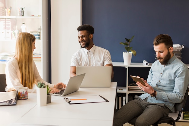 Foto gratuita compañeros alegres chateando durante el trabajo