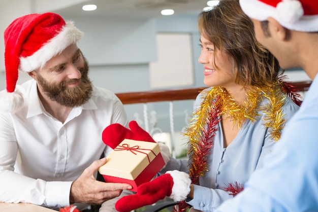 Compañeros alegres de negocios intercambiando regalos