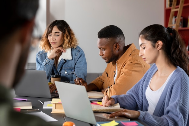 Compañeros de clase aprendiendo juntos desde una computadora portátil y notas