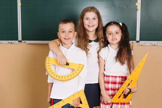 Compañeros de clase con el equipo de la lección de la geometría